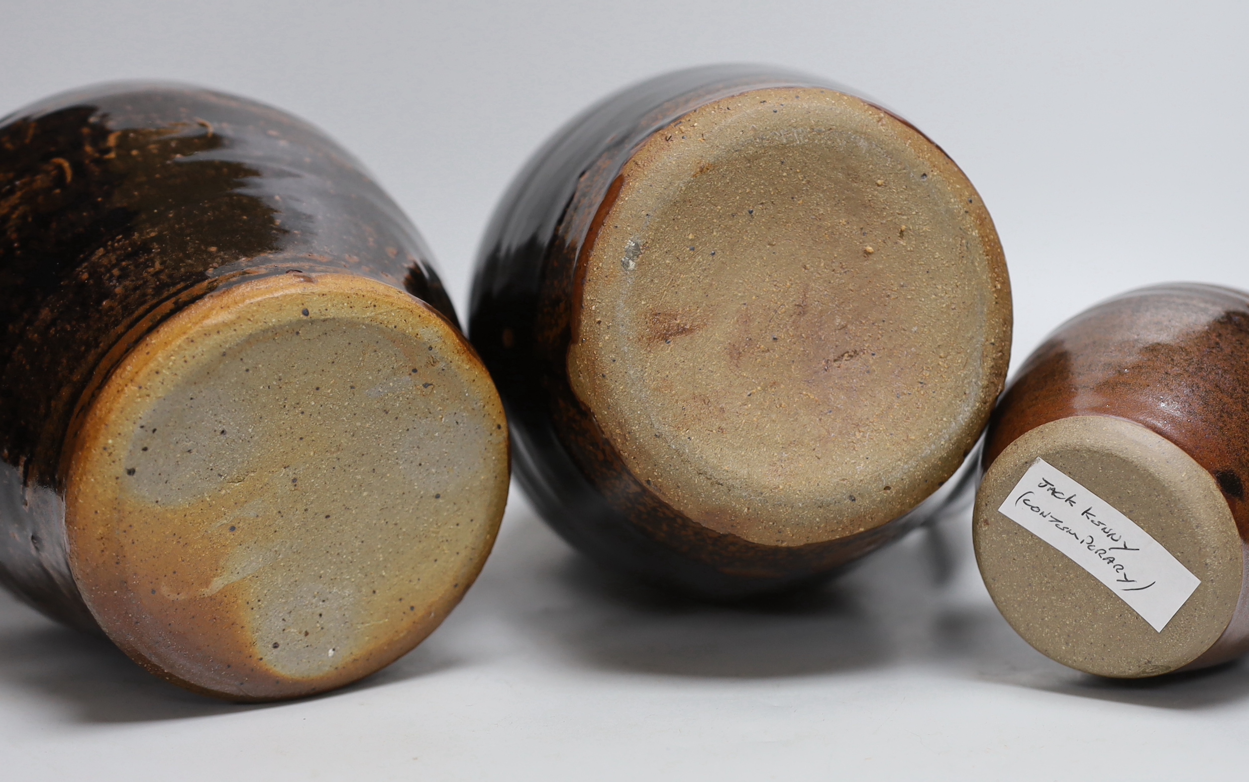 Two green glazed dishes by Jack Kenny, two dark glazed vases, a similar jug and a small bowl, tallest 26cm high